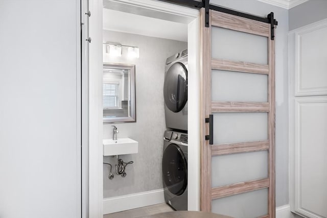 72 Edgecliff Rd Unit 72, Watertown, MA 02472 - laundry room with stacked washer / dryer, baseboards, a barn door, and wood finished floors
