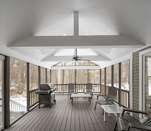 sunroom / solarium featuring vaulted ceiling with beams and a ceiling fan