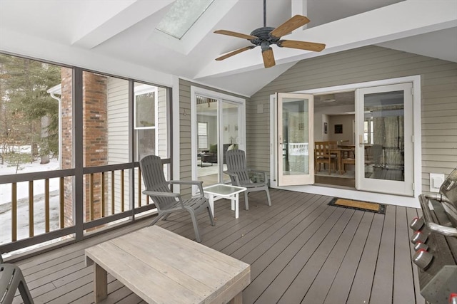 sunroom / solarium featuring lofted ceiling with skylight and ceiling fan