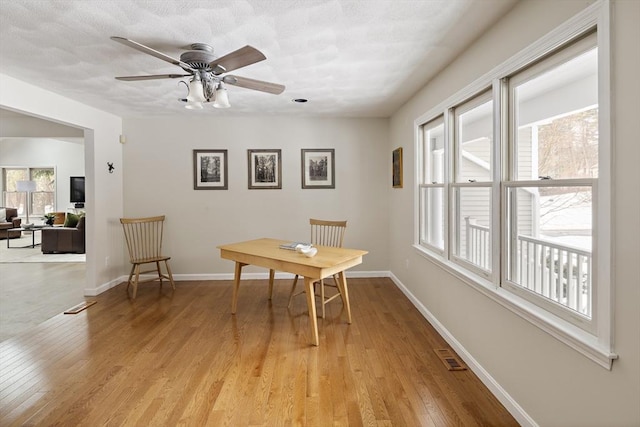 dining room with a ceiling fan, light wood-type flooring, visible vents, and baseboards