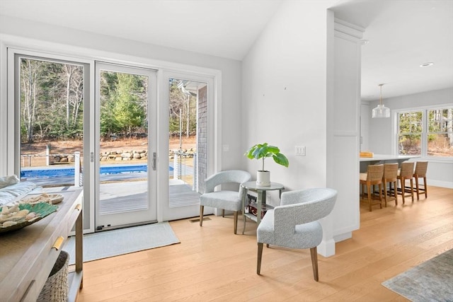 entryway with light wood-type flooring, baseboards, visible vents, and vaulted ceiling