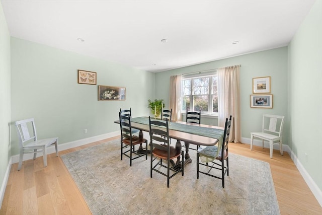 dining space with baseboards and light wood-type flooring