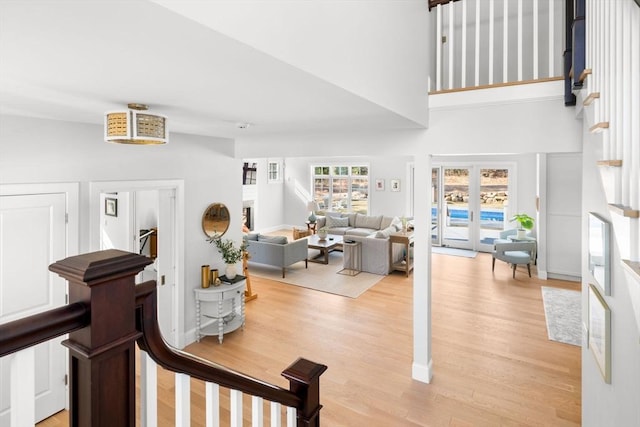 interior space featuring stairway, light wood-type flooring, and a high ceiling