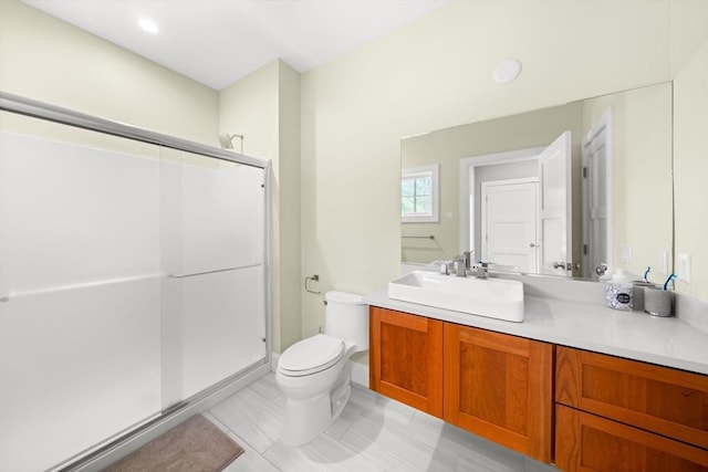 full bathroom featuring vanity, a shower stall, and toilet