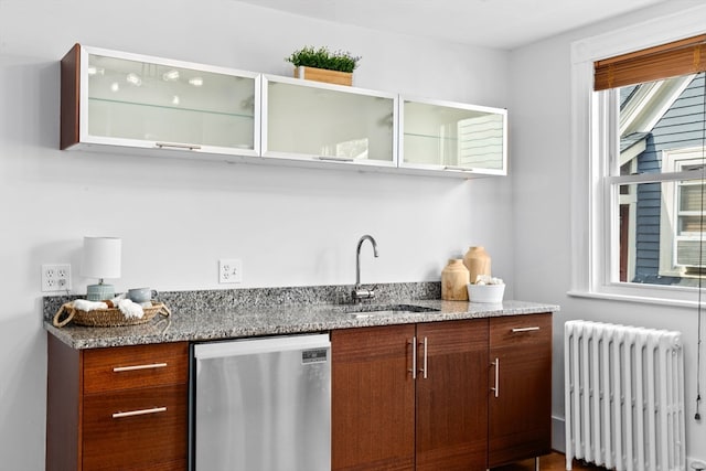 bar with radiator heating unit, stainless steel dishwasher, sink, and light stone counters