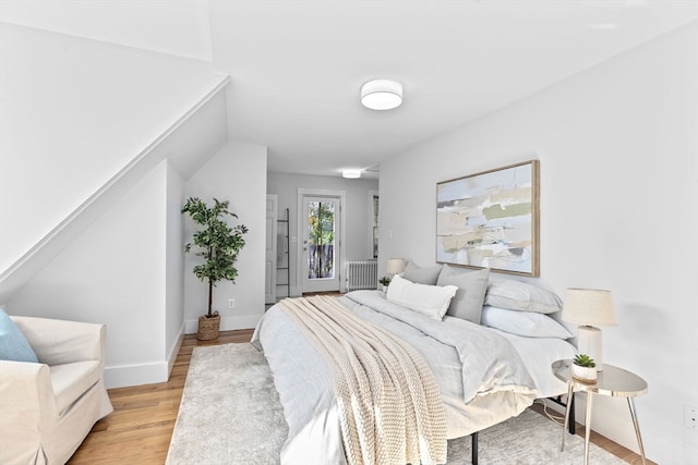 bedroom featuring light hardwood / wood-style flooring and radiator heating unit