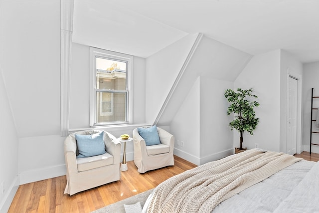 bedroom featuring a closet, hardwood / wood-style flooring, and vaulted ceiling