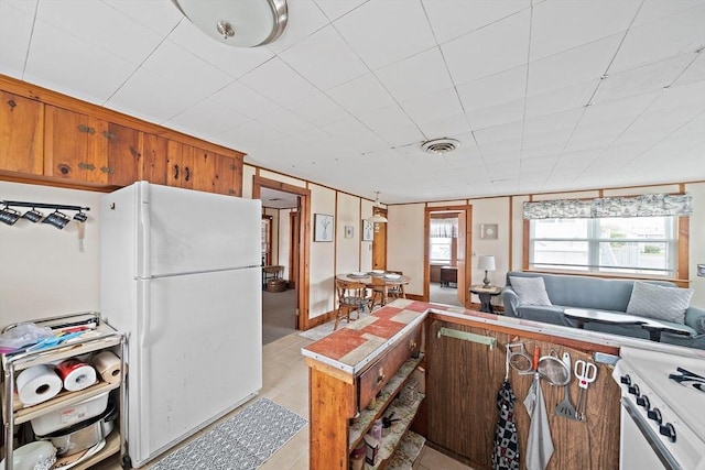 14 Mcarthur Ln, Marshfield, MA 02050 - kitchen featuring white appliances, light tile patterned floors, brown cabinets, and light countertops