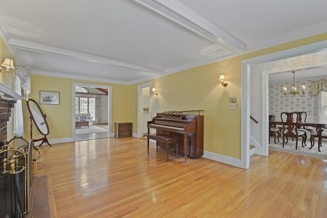 miscellaneous room featuring crown molding, hardwood / wood-style flooring, a chandelier, and a brick fireplace