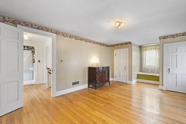 interior space with light hardwood / wood-style flooring and ensuite bath