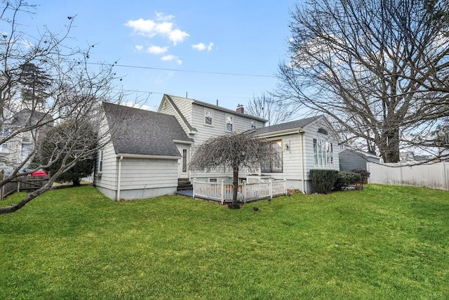 back of house featuring a deck and a yard