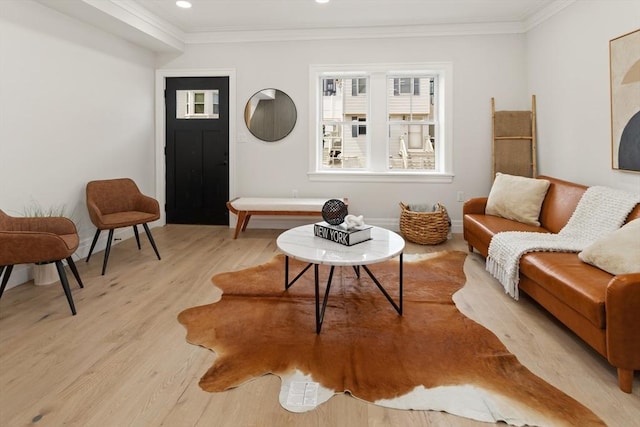 living area with light hardwood / wood-style floors and crown molding