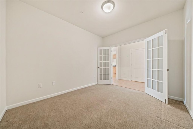 carpeted spare room with french doors