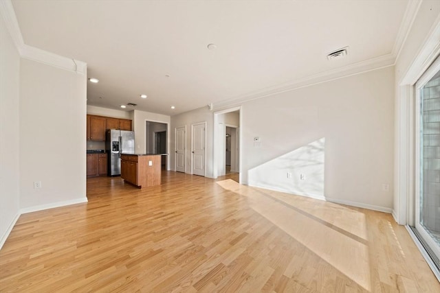 unfurnished living room with plenty of natural light, ornamental molding, and light hardwood / wood-style floors