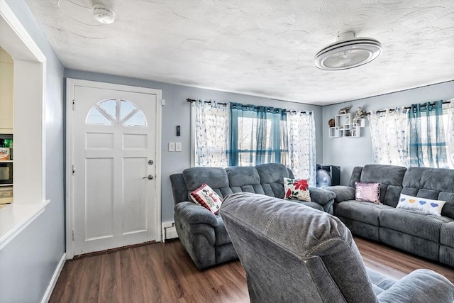 living room featuring baseboards, a baseboard radiator, wood finished floors, and a textured ceiling
