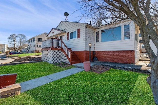 bungalow-style home featuring brick siding, a front yard, and stairway