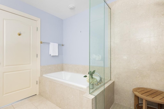 bathroom featuring plus walk in shower, tile patterned flooring, and tile walls