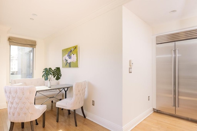 dining space with crown molding and light hardwood / wood-style floors