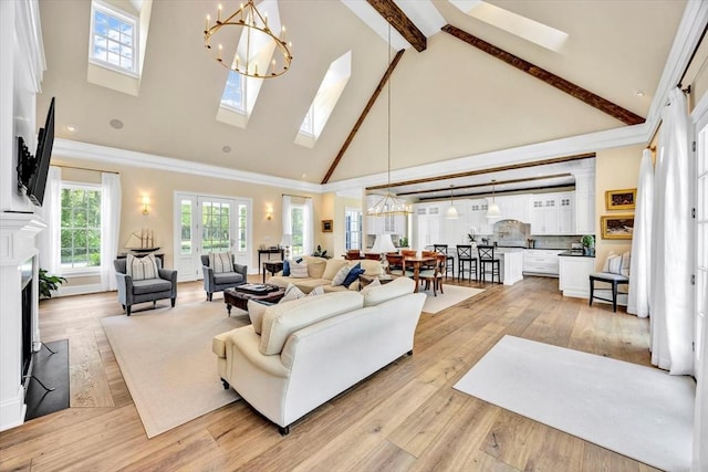 10 Herring Gull Rd, Mashpee, MA 02649 - living area featuring high vaulted ceiling, a chandelier, beam ceiling, a skylight, and light wood-type flooring