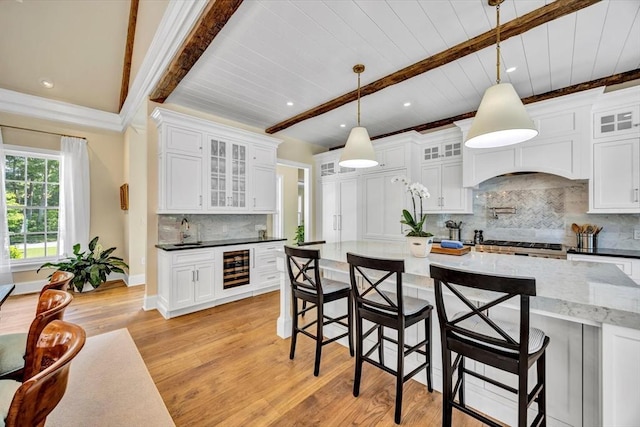 10 Herring Gull Rd, Mashpee, MA 02649 - kitchen featuring light wood-style floors, a kitchen bar, tasteful backsplash, white cabinetry, and a wood ceiling with exposed beams