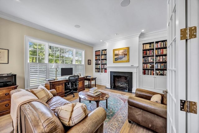 10 Herring Gull Rd, Mashpee, MA 02649 - living area with light wood-style floors, crown molding, a fireplace with flush hearth, built in shelves, and a desk