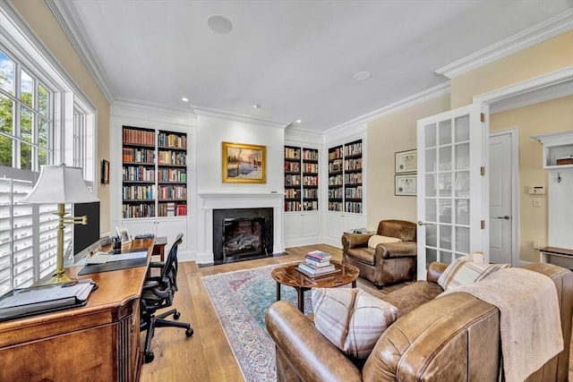 10 Herring Gull Rd, Mashpee, MA 02649 - office with built in shelves, a fireplace with flush hearth, ornamental molding, light wood-type flooring, and recessed lighting