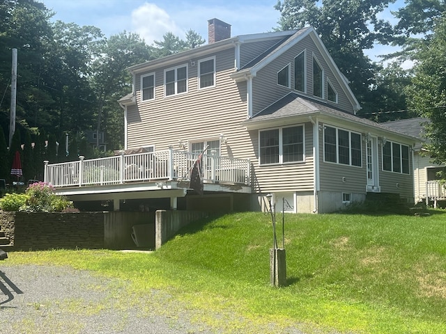 rear view of house with a lawn and a deck