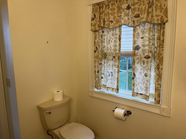 bathroom with plenty of natural light and toilet