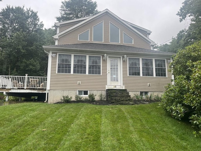 view of front of property with a wooden deck and a front lawn