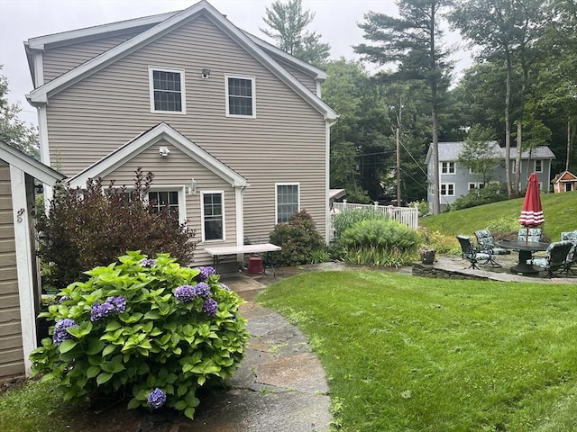 back of house with a yard and a patio