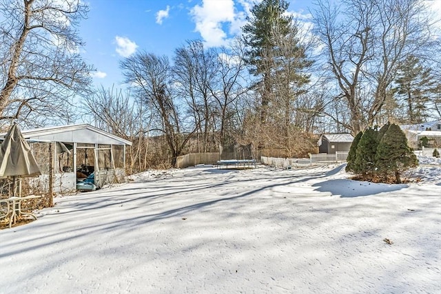 yard covered in snow featuring a trampoline