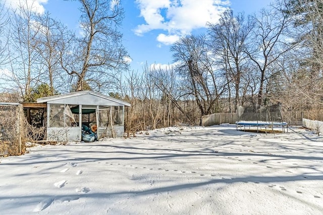 yard layered in snow with a trampoline