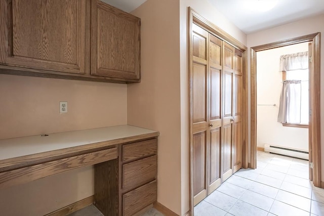 18 Oakwind Holw, Leominster, MA 01453 - kitchen featuring a baseboard radiator, light countertops, brown cabinets, and light tile patterned flooring