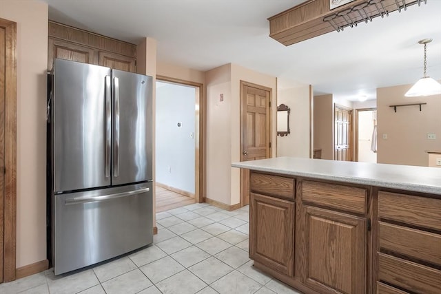 18 Oakwind Holw, Leominster, MA 01453 - kitchen featuring freestanding refrigerator, light tile patterned floors, light countertops, baseboards, and brown cabinets