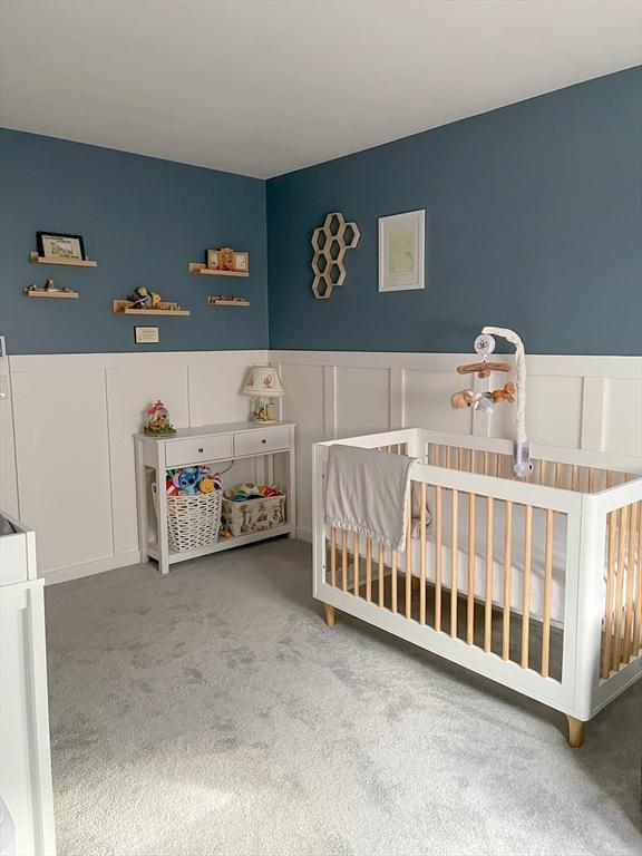 121 Depot Rd, Hatfield, MA 01066 - bedroom with a decorative wall, carpet floors, a nursery area, and wainscoting