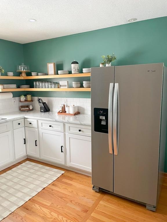 121 Depot Rd, Hatfield, MA 01066 - kitchen with stainless steel refrigerator with ice dispenser, open shelves, decorative backsplash, white cabinets, and a textured ceiling