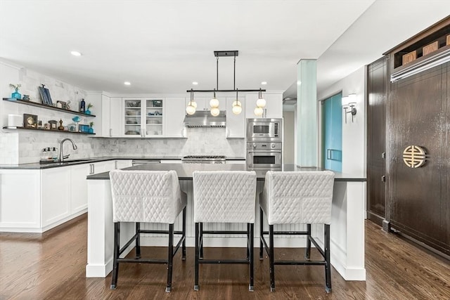 65 E India Row Unit 28Ef, Boston, MA 02110 - kitchen with appliances with stainless steel finishes, under cabinet range hood, tasteful backsplash, white cabinets, and recessed lighting