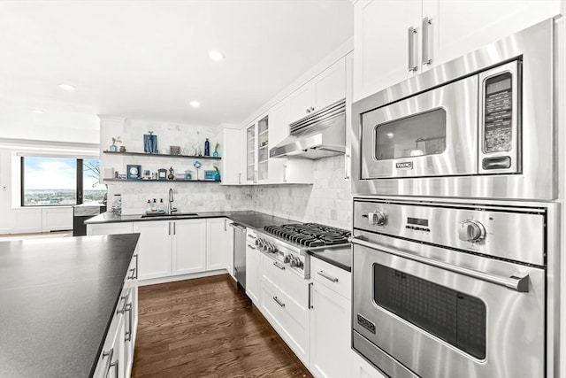 65 E India Row Unit 28Ef, Boston, MA 02110 - kitchen with appliances with stainless steel finishes, dark countertops, range hood, open shelves, and white cabinetry