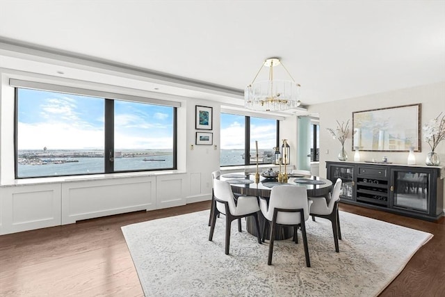 65 E India Row Unit 28Ef, Boston, MA 02110 - dining area featuring a chandelier, wood finished floors, a decorative wall, and beverage cooler