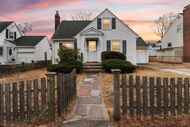 view of front facade featuring a fenced front yard, concrete driveway, a chimney, and a garage