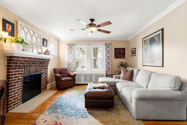 34 Sheafe St Unit 1, Brookline, MA 02467 - living room with radiator heating unit, ornamental molding, wood finished floors, ceiling fan, and a fireplace