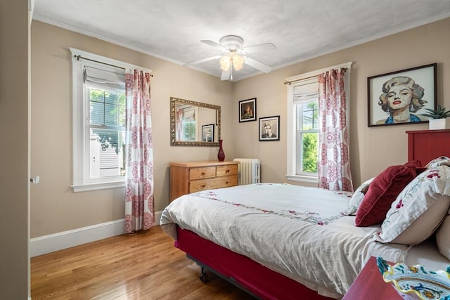 34 Sheafe St Unit 1, Brookline, MA 02467 - bedroom with radiator, wood finished floors, multiple windows, baseboards, and ornamental molding