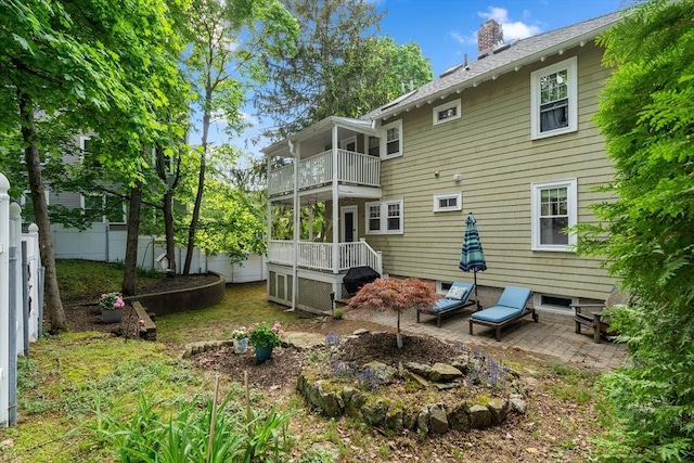 34 Sheafe St Unit 1, Brookline, MA 02467 - rear view of property featuring a balcony, a fenced backyard, a chimney, and a patio area