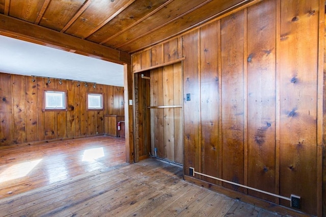 spare room featuring wood ceiling, hardwood / wood-style flooring, and wooden walls