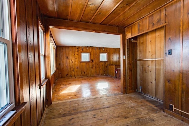 bonus room with wood-type flooring, wooden ceiling, and wooden walls