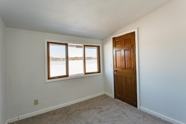 carpeted empty room with vaulted ceiling and a water view