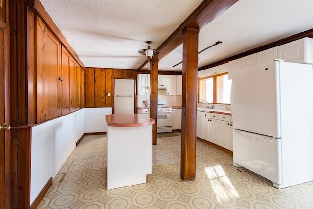 kitchen featuring white cabinetry, a center island, a textured ceiling, white appliances, and range hood