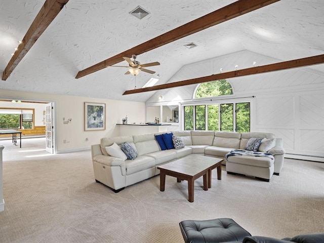 living area featuring light carpet, a healthy amount of sunlight, visible vents, and a textured ceiling