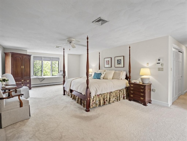 bedroom with a baseboard heating unit, light carpet, visible vents, and a ceiling fan