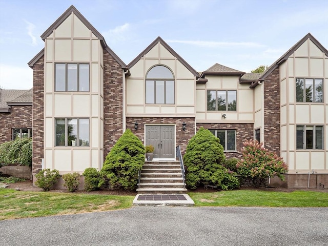 view of front facade featuring brick siding and stucco siding